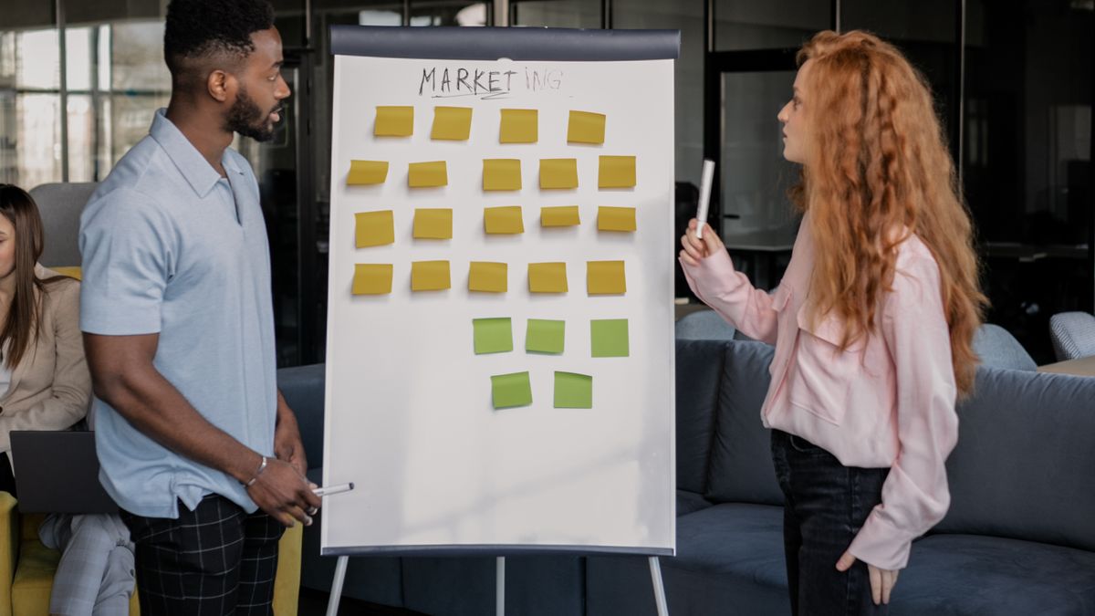 Two people planning a marketing campaign on a whiteboard.